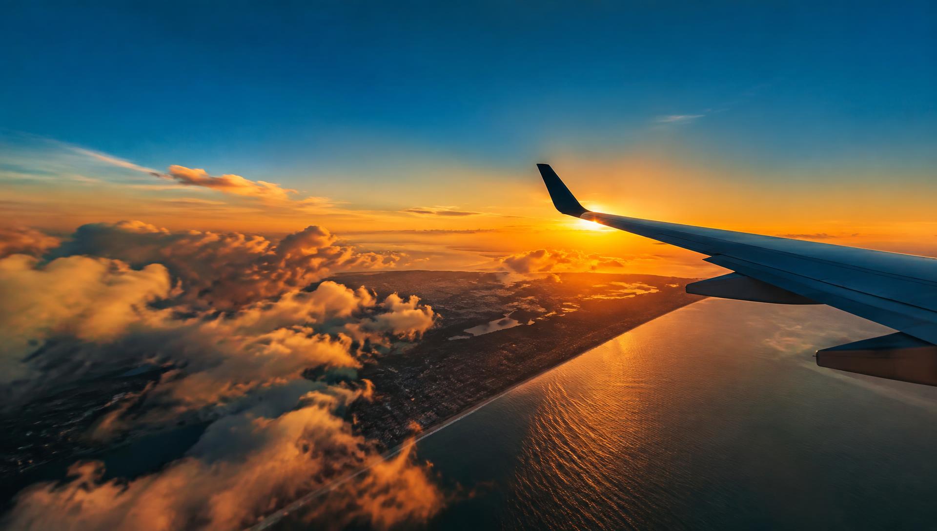 View of a sunset coastline from an aircraft window